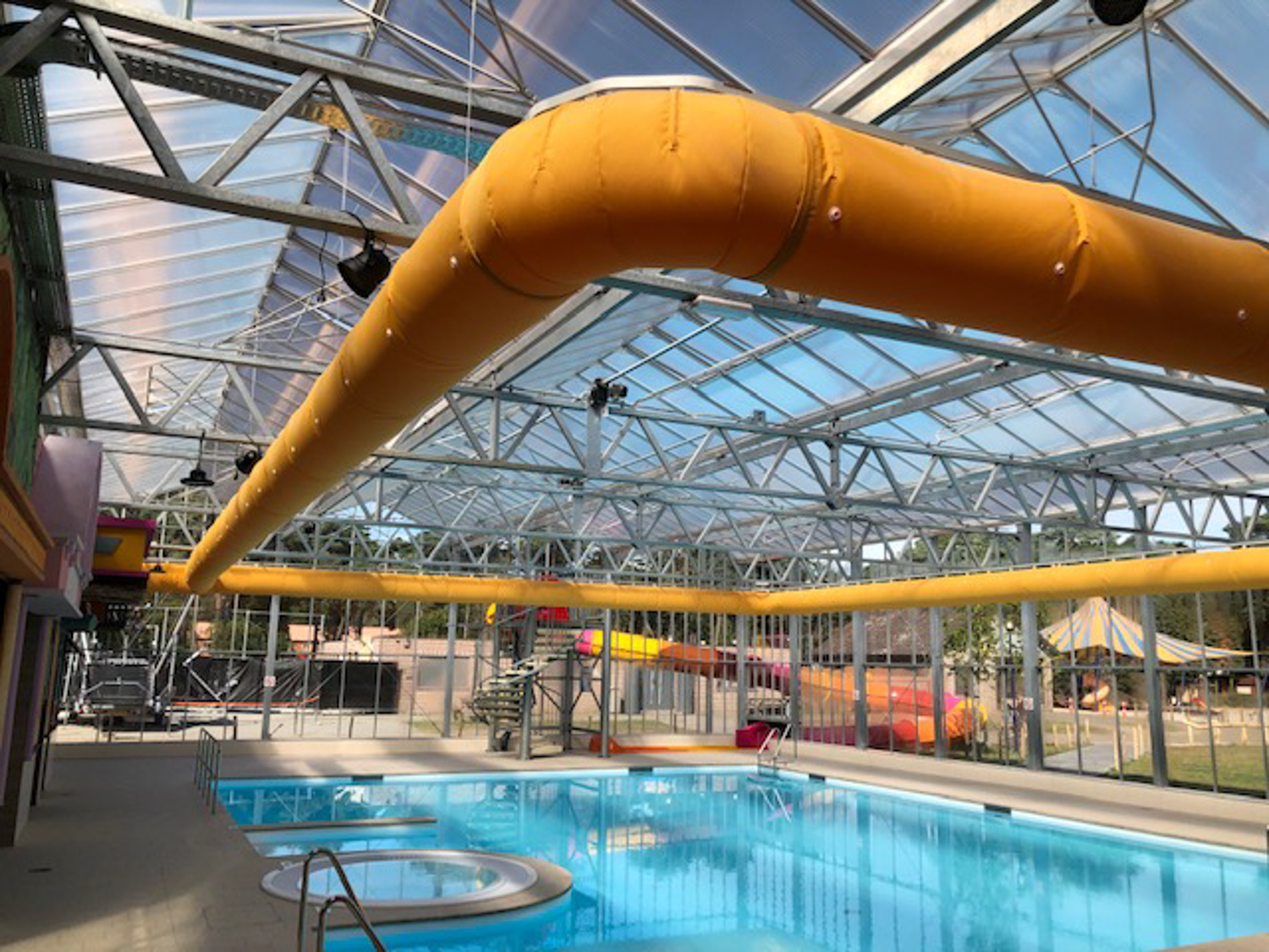Orange fabric duct installed inside a swimming pool facility, CA