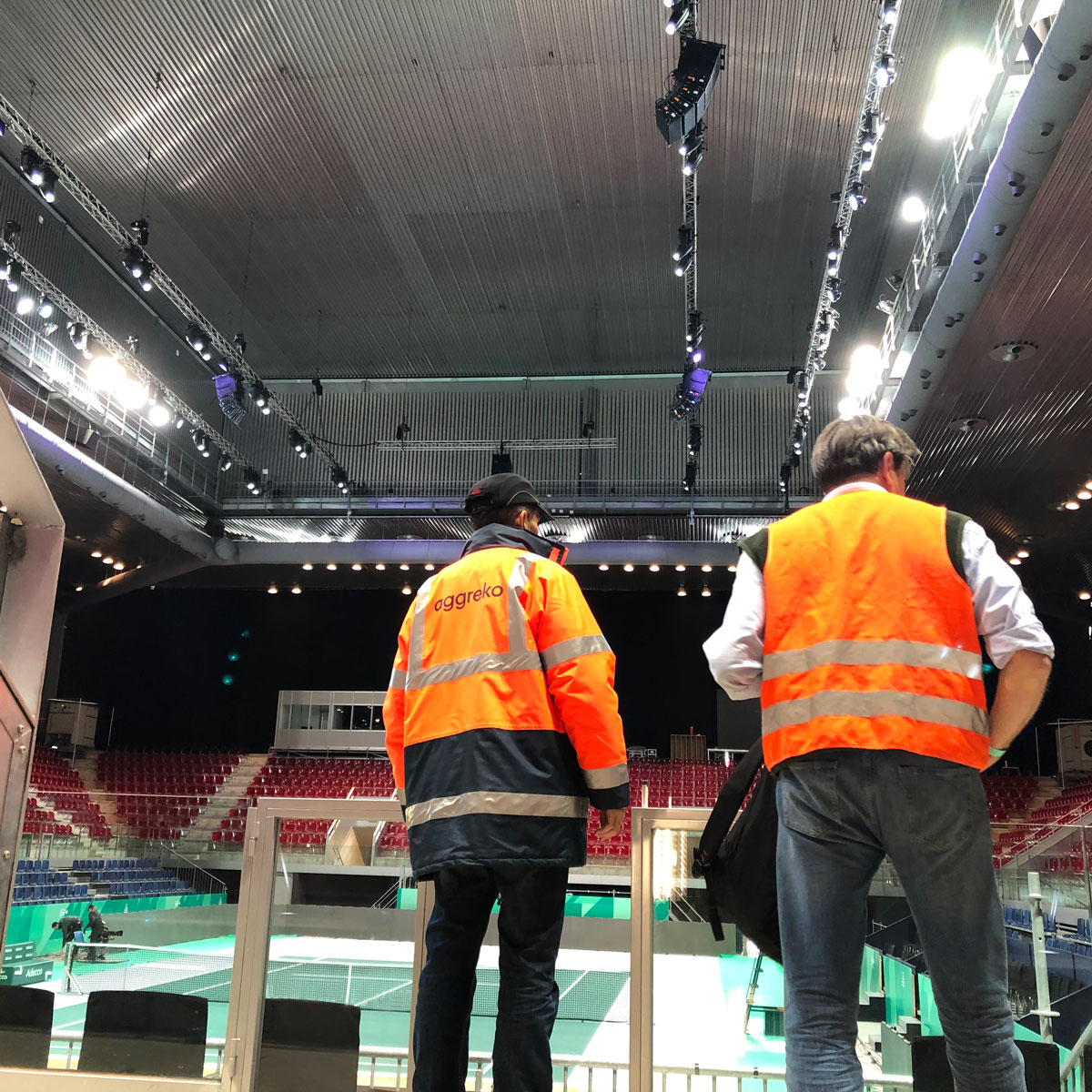 Two men in uniforms standing in an indoor tennis court, 2