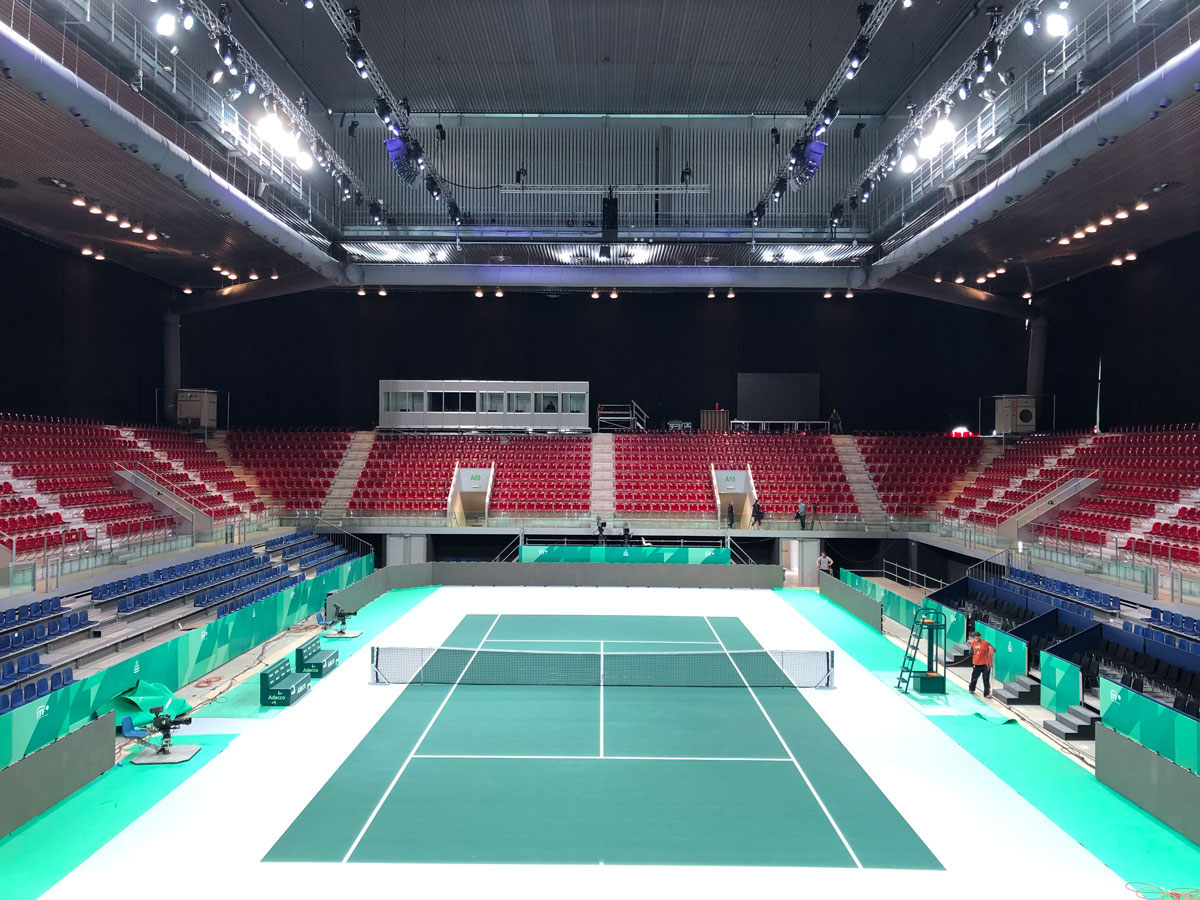 Grey duct systems installed inside an indoor tennis court, 2