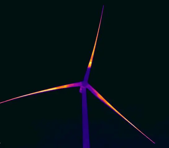 Infrared photo of wind turbine blades with the BorealisWind Ice Protection System installed. The blades glow orange and red on the black background highlighting the heated blades which help eliminate icing events before they start and remove any ice buildup.