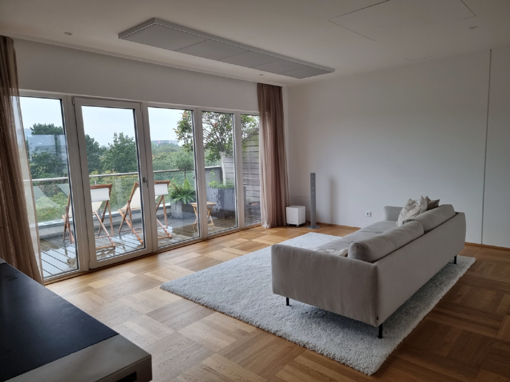 Modernes Wohnzimmer mit integrierten Luftkanälen in der Decke für leise und gleichmäßige Luftverteilung.