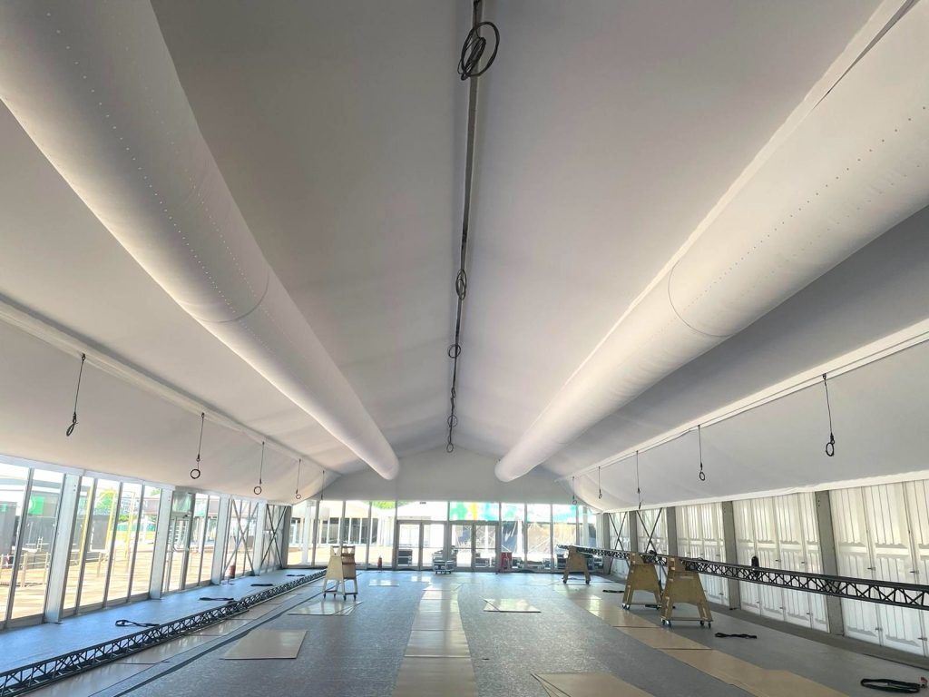 Großes Eventzelt mit integrierten textilen Luftkanälen an der Decke für gleichmäßige und effiziente Klimatisierung.