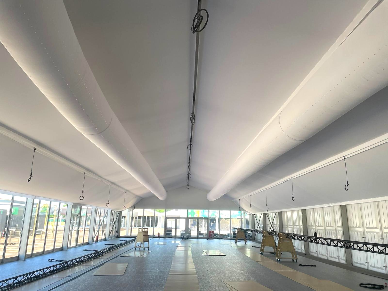 Großes Eventzelt mit integrierten textilen Luftkanälen an der Decke für gleichmäßige und effiziente Klimatisierung.