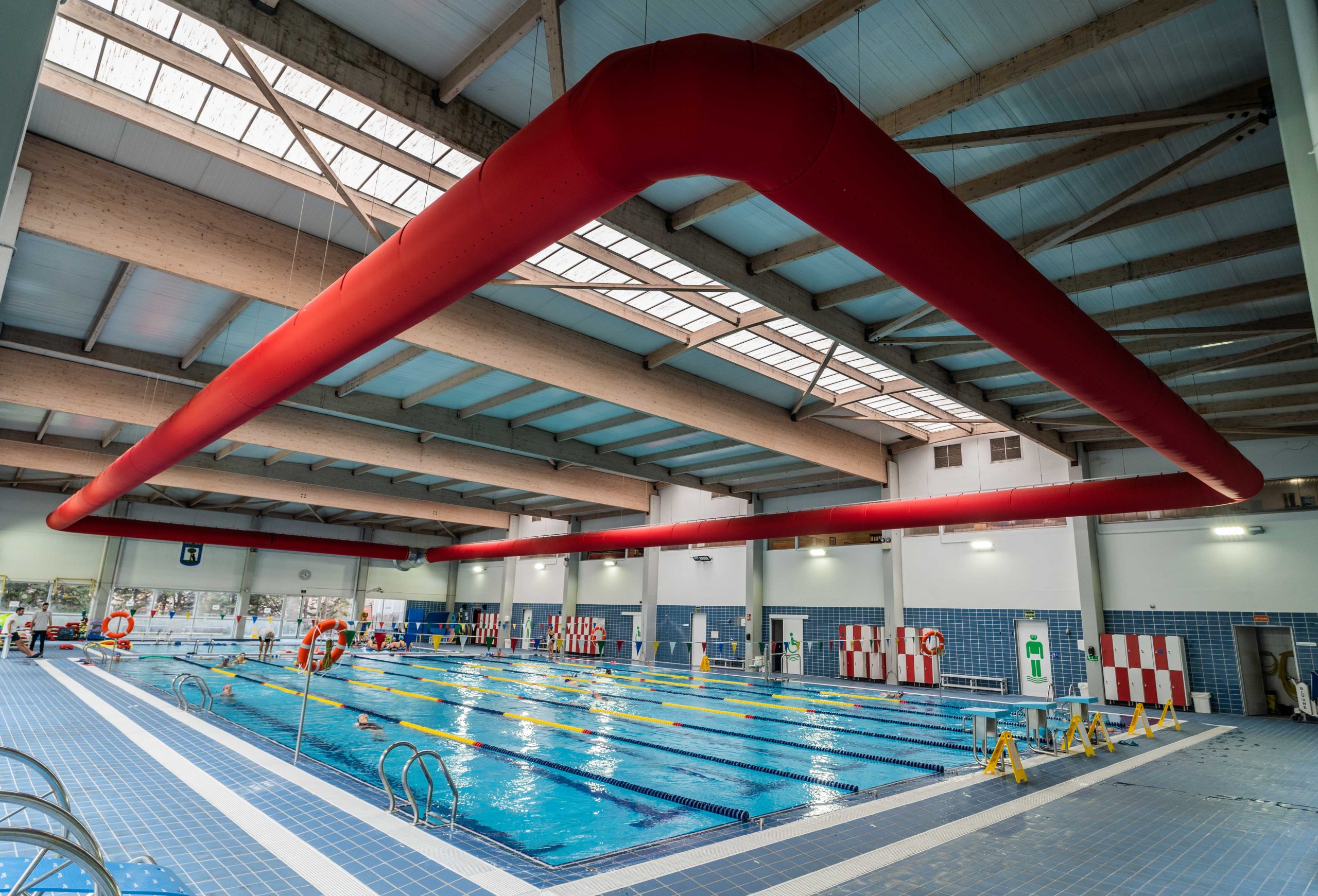 Rote Textil-Luftkanäle in der Schwimmhalle des Hallenbads Faustina Valladolid in Vicálvaro.