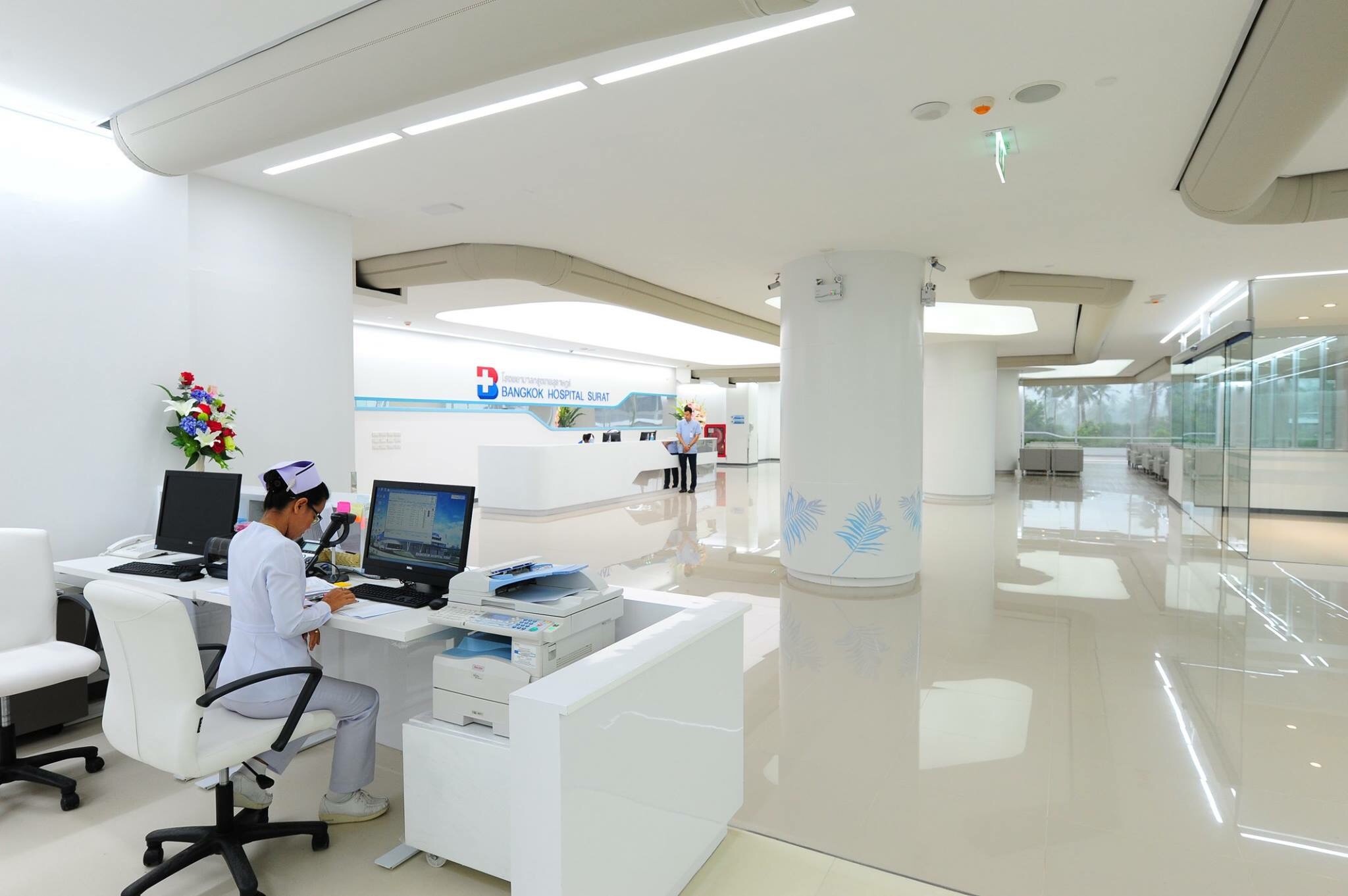 Offener Klinikbereich mit Pflegearbeitsplatz und umlaufenden textilkanälen, die in die Deckenstruktur eingebettet sind.