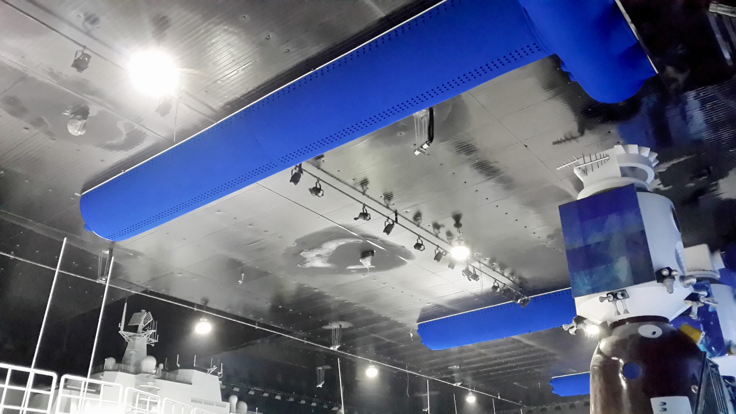 Industriehalle mit blauen Textilkanälen an der Decke, integrierter Beleuchtung und technischer Ausstattung in einer modernen Produktionsumgebung.