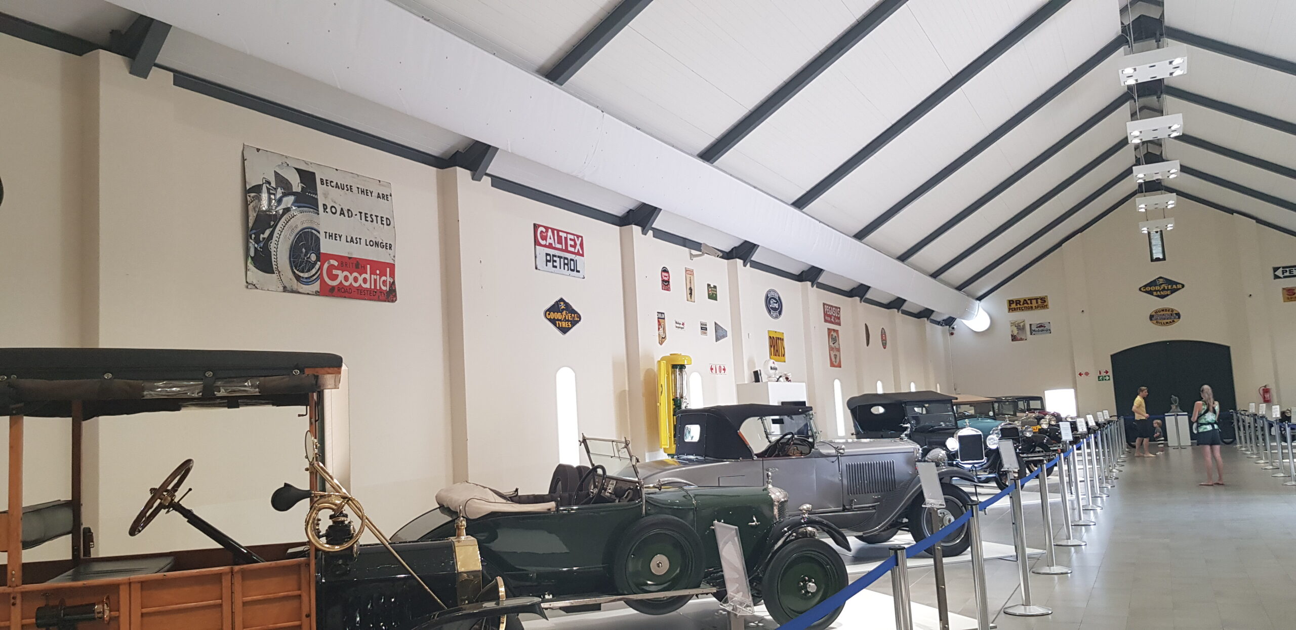 Ausstellungshalle mit Oldtimern und weißem Textil-Luftkanal entlang der Decke, kombiniert mit Beleuchtung und moderner Hallenarchitektur.
