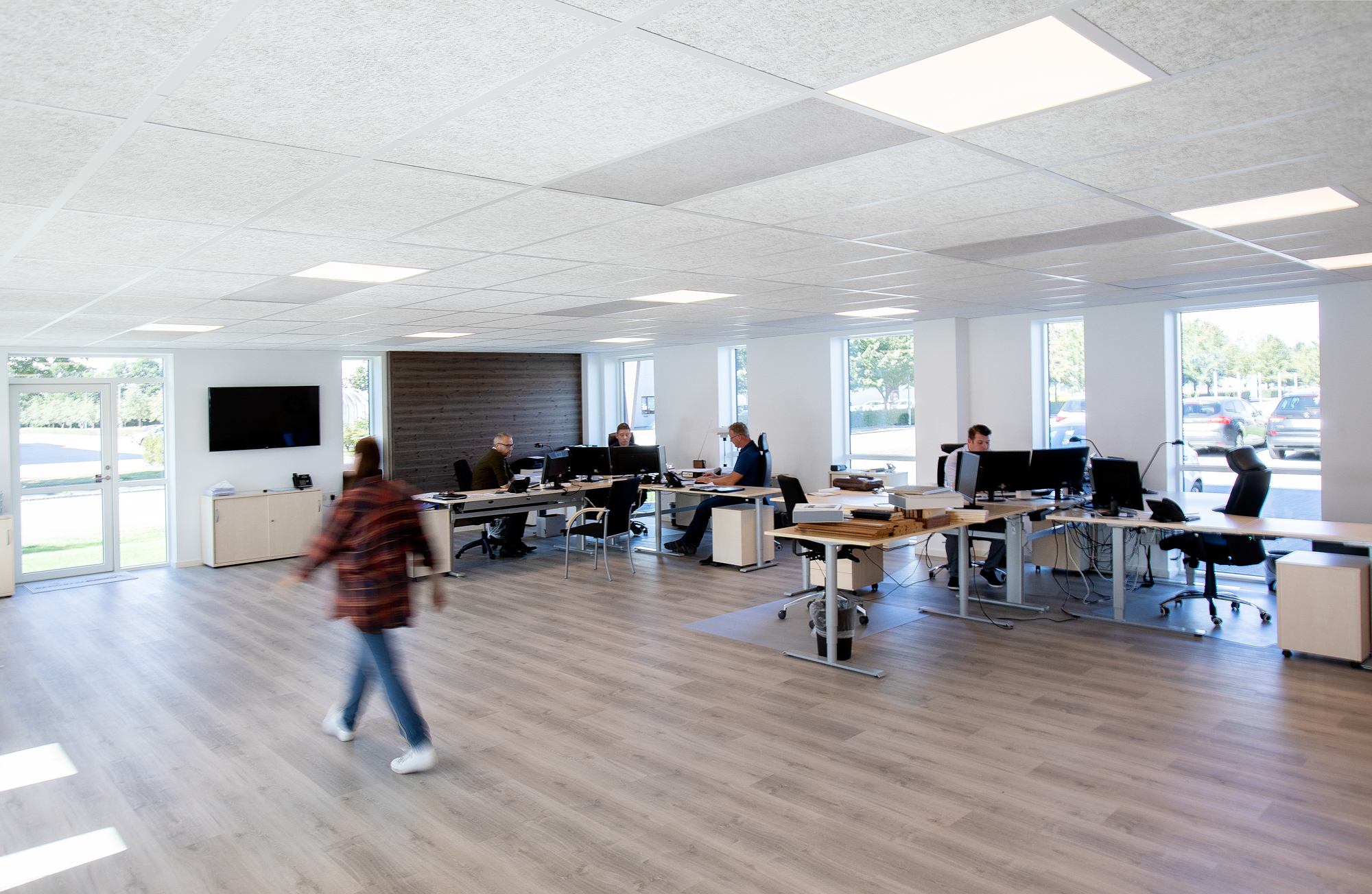 Bright open-plan office with workstations, acoustic ceiling panels, and flush-mounted ceiling diffusers for even air distribution.