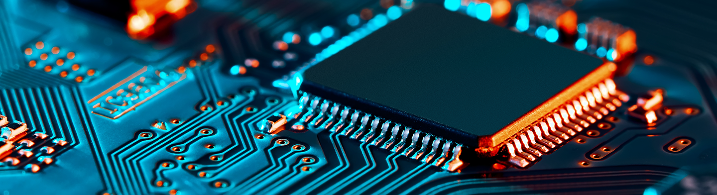 Mikrochip auf beleuchteter elektronischer Leiterplatte mit detaillierten Leiterbahnen und Halbleiterverbindungen.