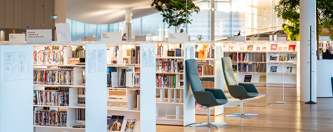 Bibliotheksbereich mit offenen Bücherregalen, Lesesesseln und ruhiger Atmosphäre in moderner Innenarchitektur.