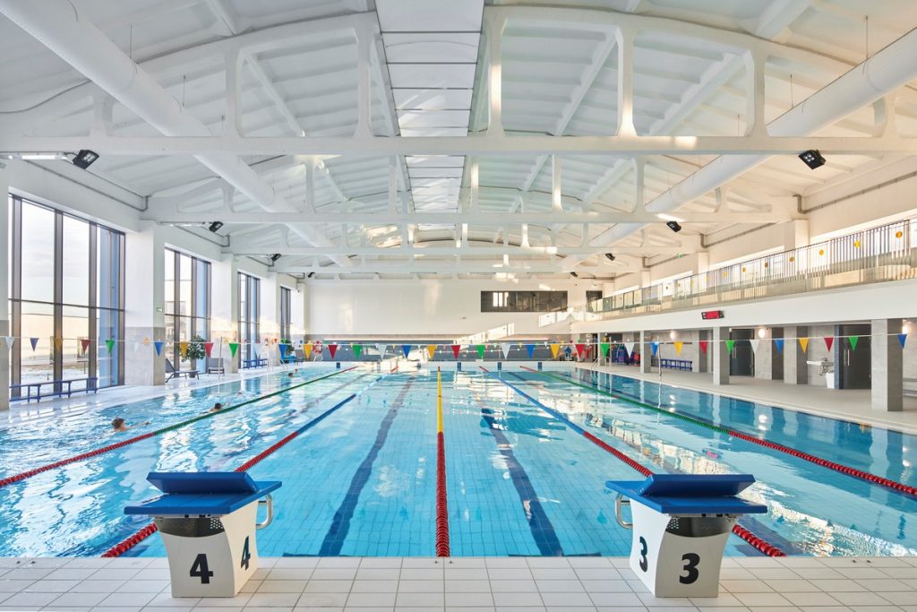 FabricAir's Return Air System is shown aesthetically installed in a pool. A taut rectangular structure complete with a perforated fabric draws contaminated air from the space complementing the supply system for perfect air distribution.