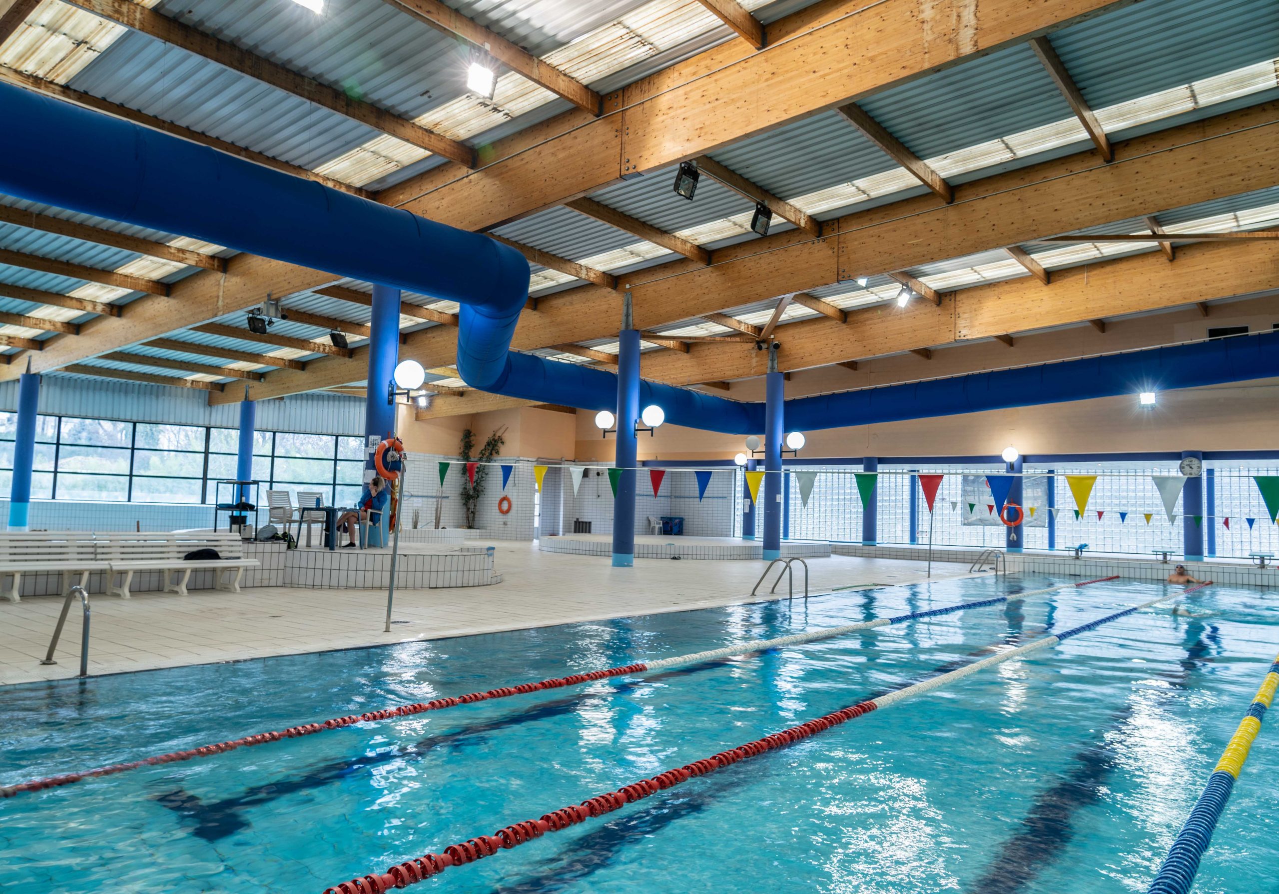 Instalación de conductos textiles en piscina municipal para confort térmico.