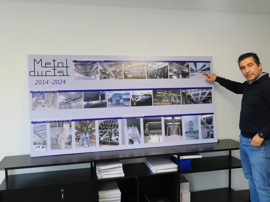 Der Geschäftsführer des Installationsunternehmens Metalduct zeigt eine seiner Installationen mit textilen Lüftungskanälen.