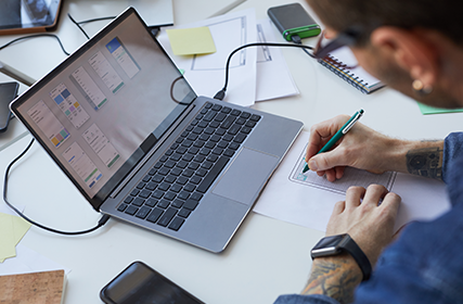 Man working on a laptop inside an office, IN