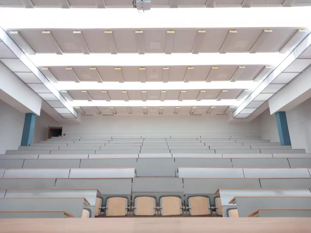 White rectangle-shaped fabric ducts installed on the left and right side of the ceiling in the Vilnius Gediminas Technical University auditorium to improve the indoor air quality and offer draft free airflow to ensure a comfortable learning environment for faculty and students.