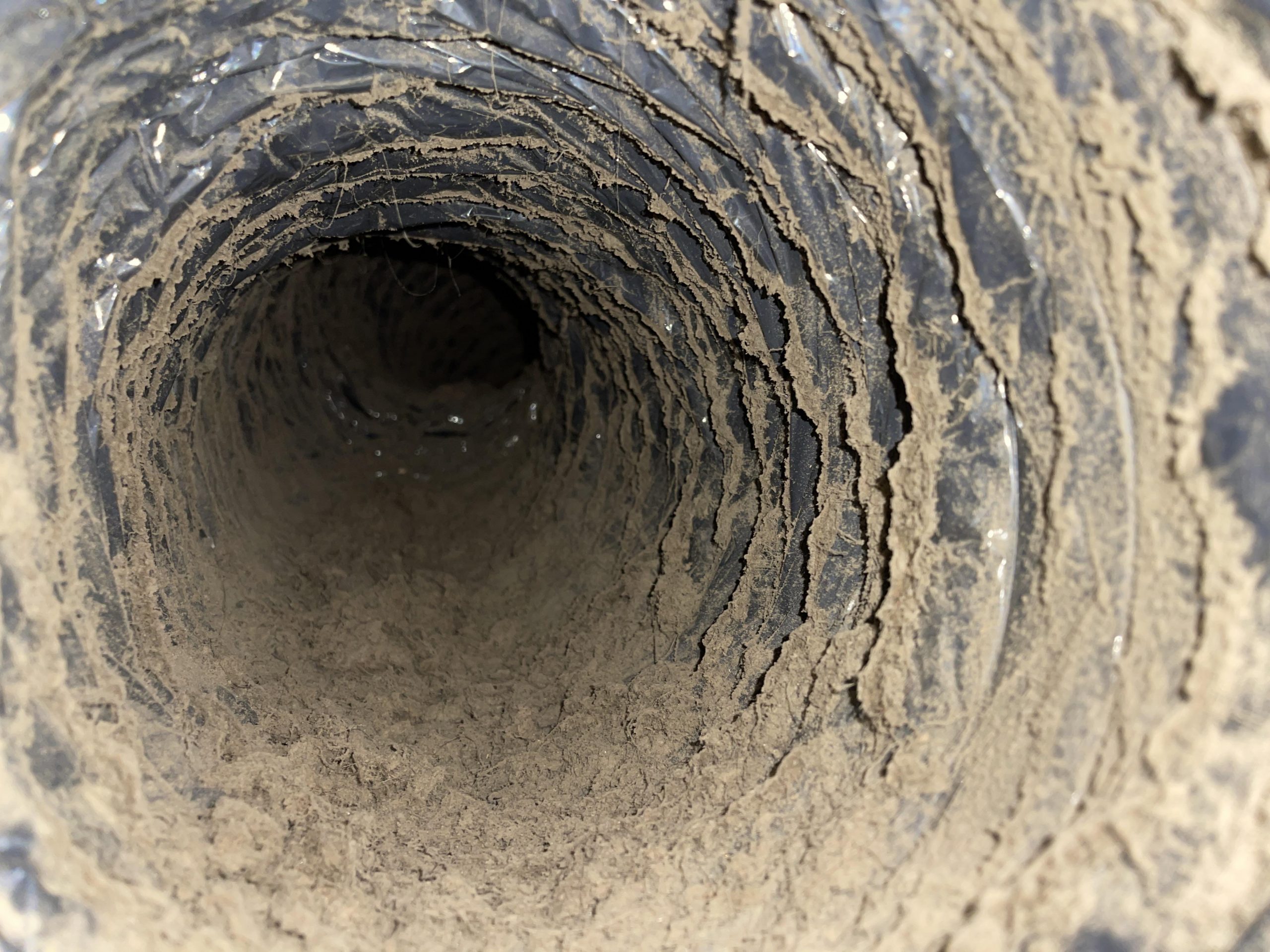 Ducto metálico con acumulación de polvo y suciedad, ejemplo de falta de mantenimiento de ductos en sistemas de climatización.