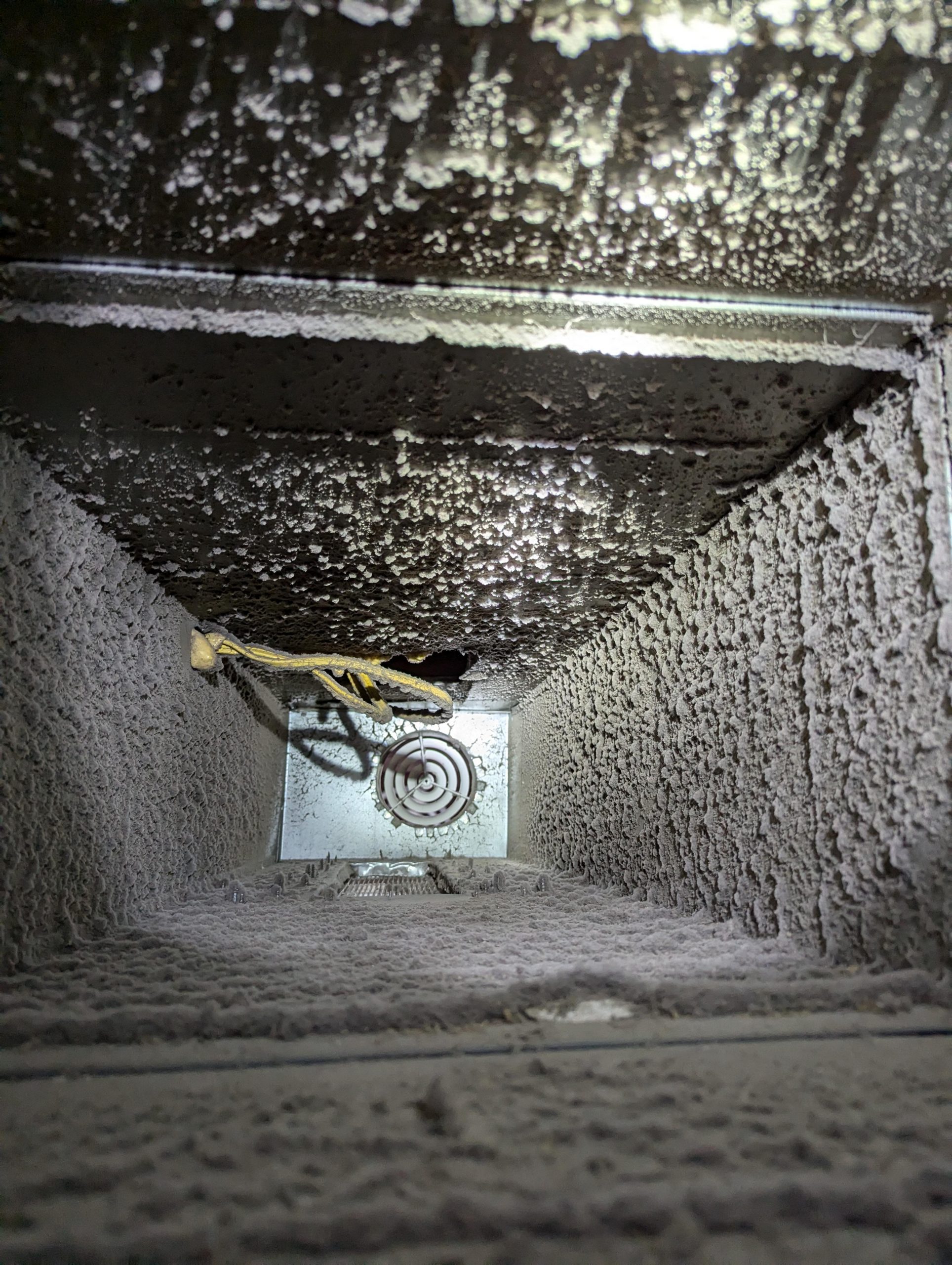 Interior de ducto metálico deteriorado y con partículas contaminantes, mostrando la importancia del mantenimiento de ductos.