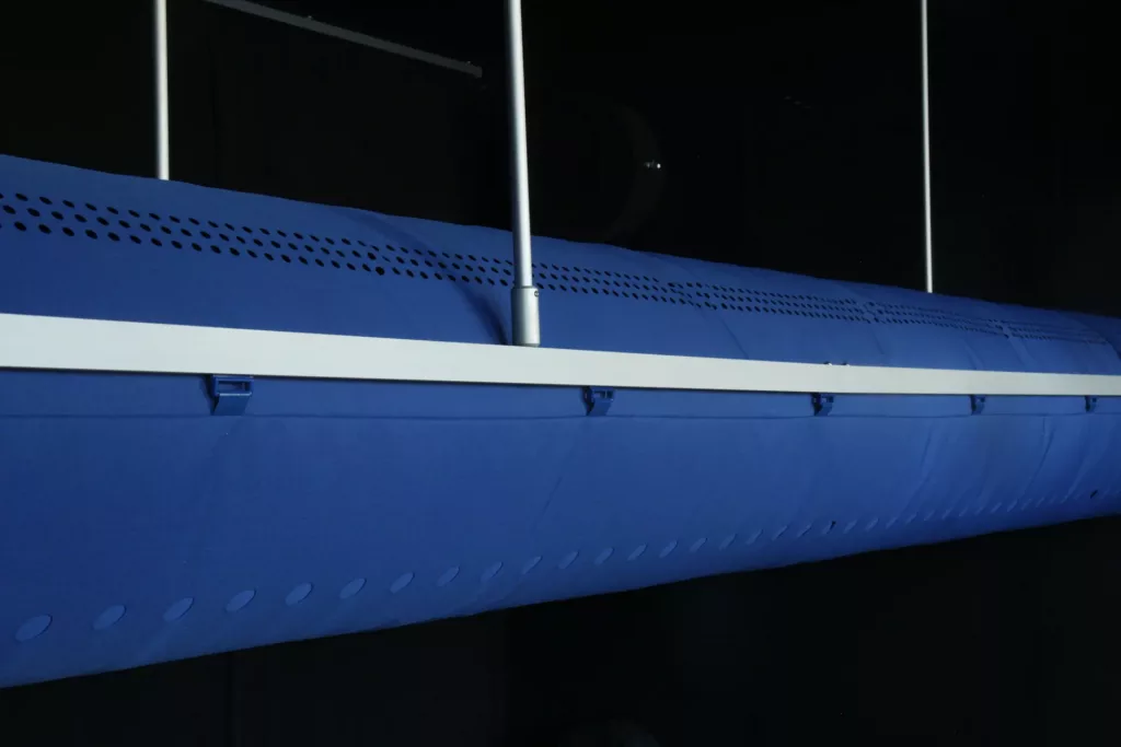 FabricAir Varioduct mavi kumaş kanal, çubuklar ve plastik kaydırıcılarla çift ray üzerine asılı