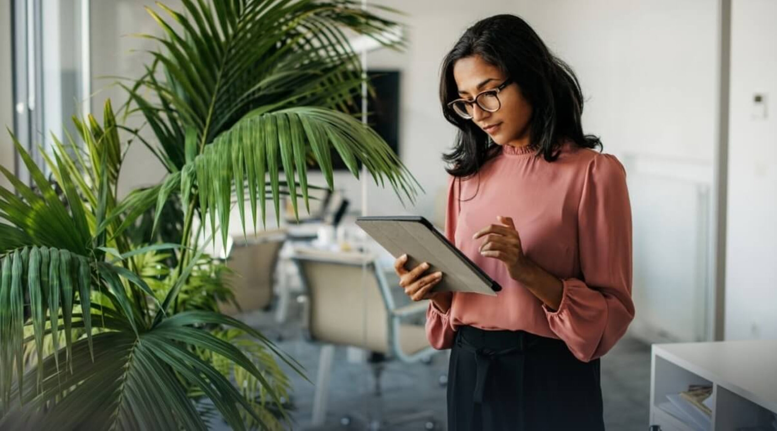 Woman working on a laptop inside an office, UK, 2