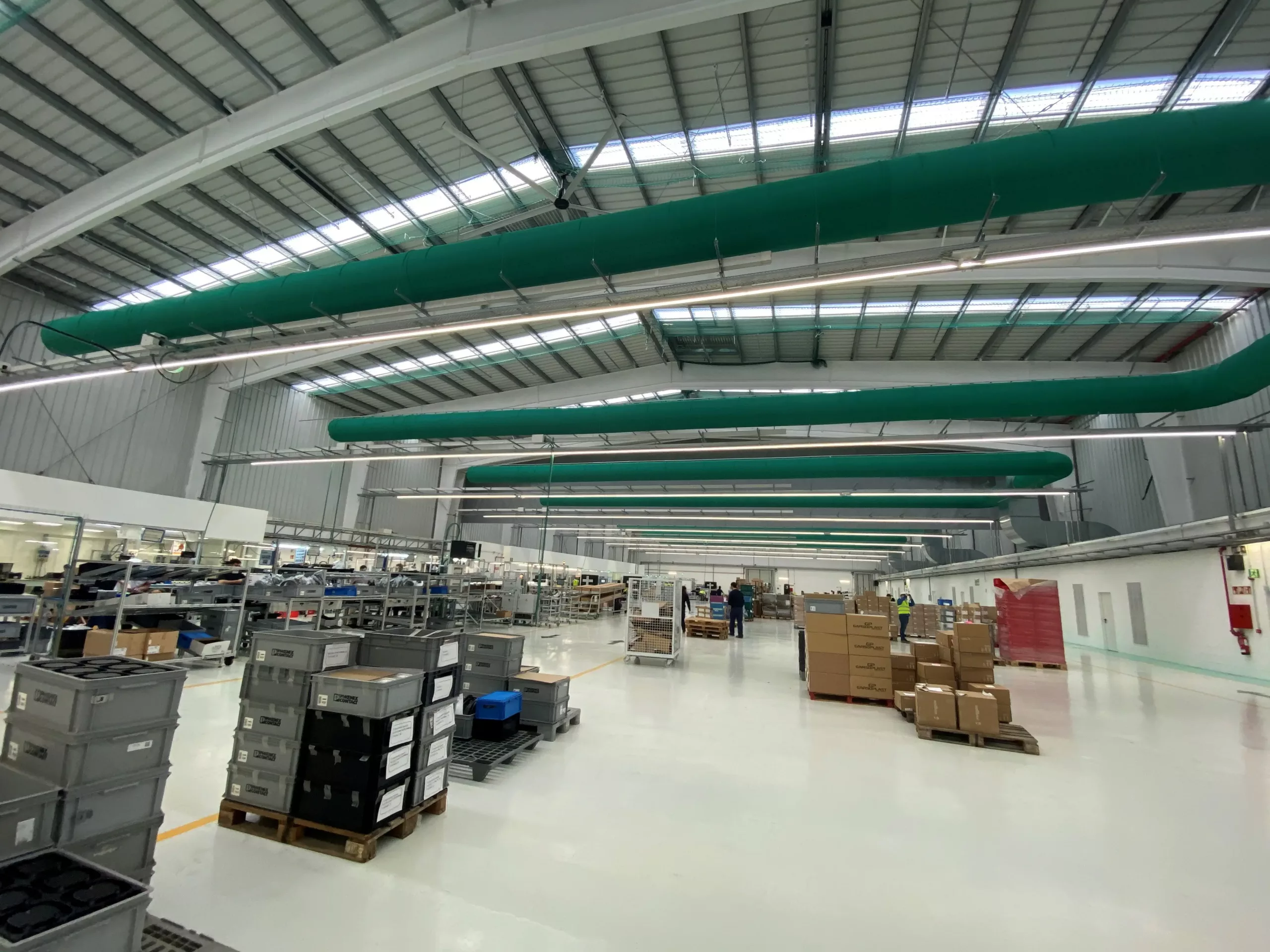 Industrial air duct systems with green ventilation ducts inside a warehouse, UK