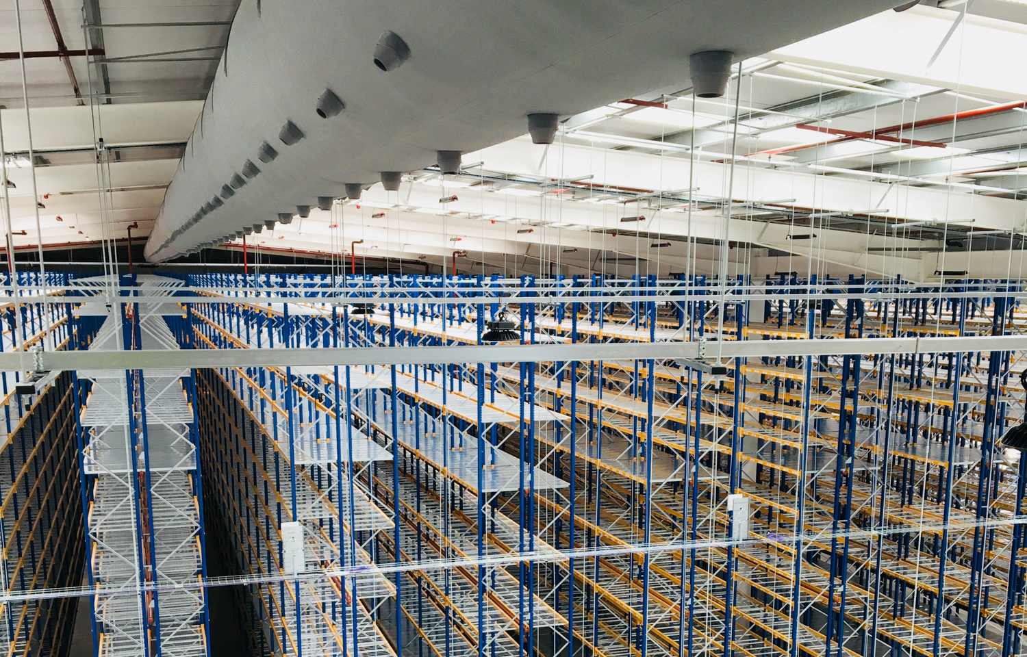 Industrial ductwork system with grey air duct design inside a warehouse, UK