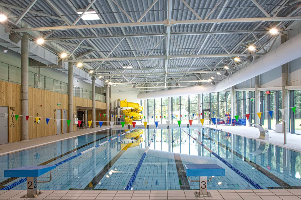 Fabric-based HVAC ducting installed in an indoor pool area in Plungė, Lithuania. White fabric duct with nozzles and PerfoFlow to distribute air and prevent condensation that leads to corrosion.