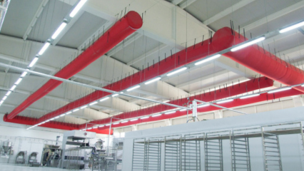 Red FabricAir ducts installed in a manufacturing facility