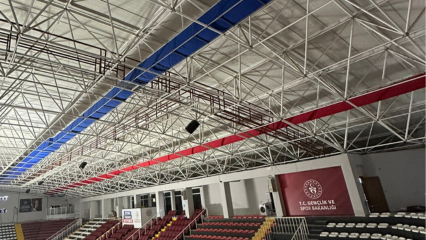 Blue and red fabric ducting provides ventilation and improves air quality in the Gazanfer Bilge Sports Hall in Istanbul