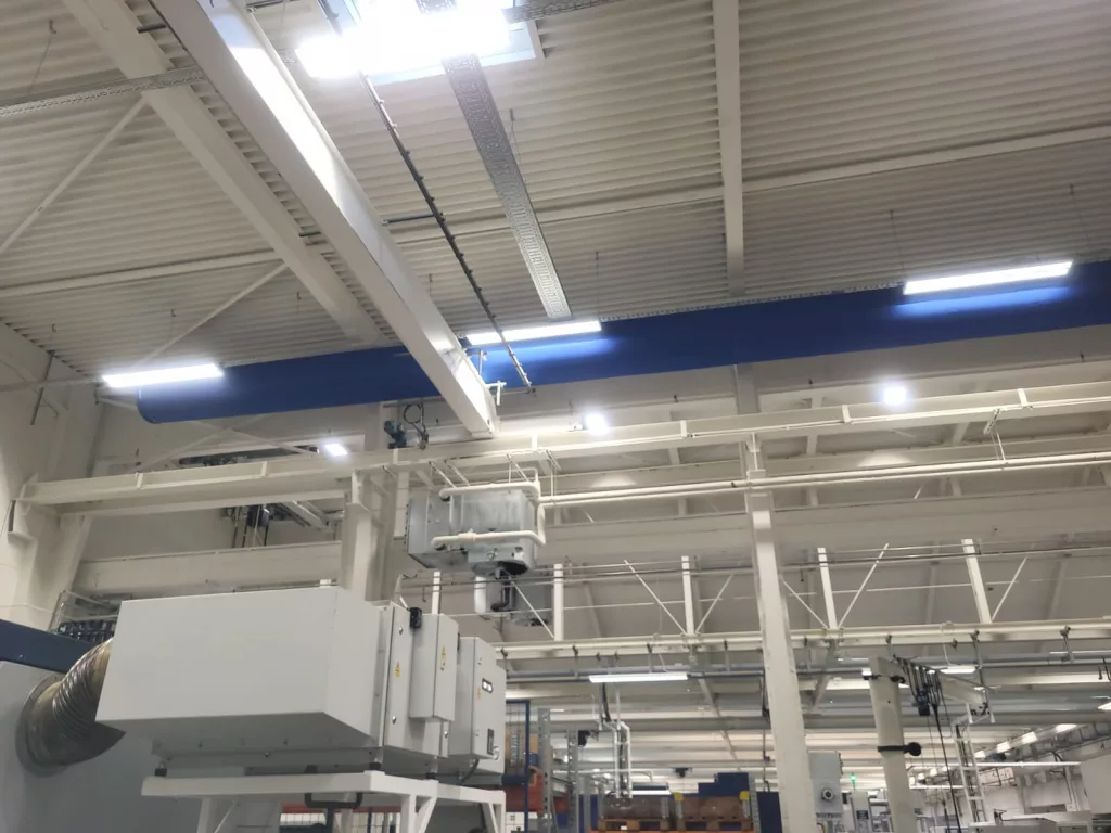Blue fabric ducts featuring the 360 hoops shape retention system utilizing a Type 08 suspension are installed in a industrial manufacturing facility.