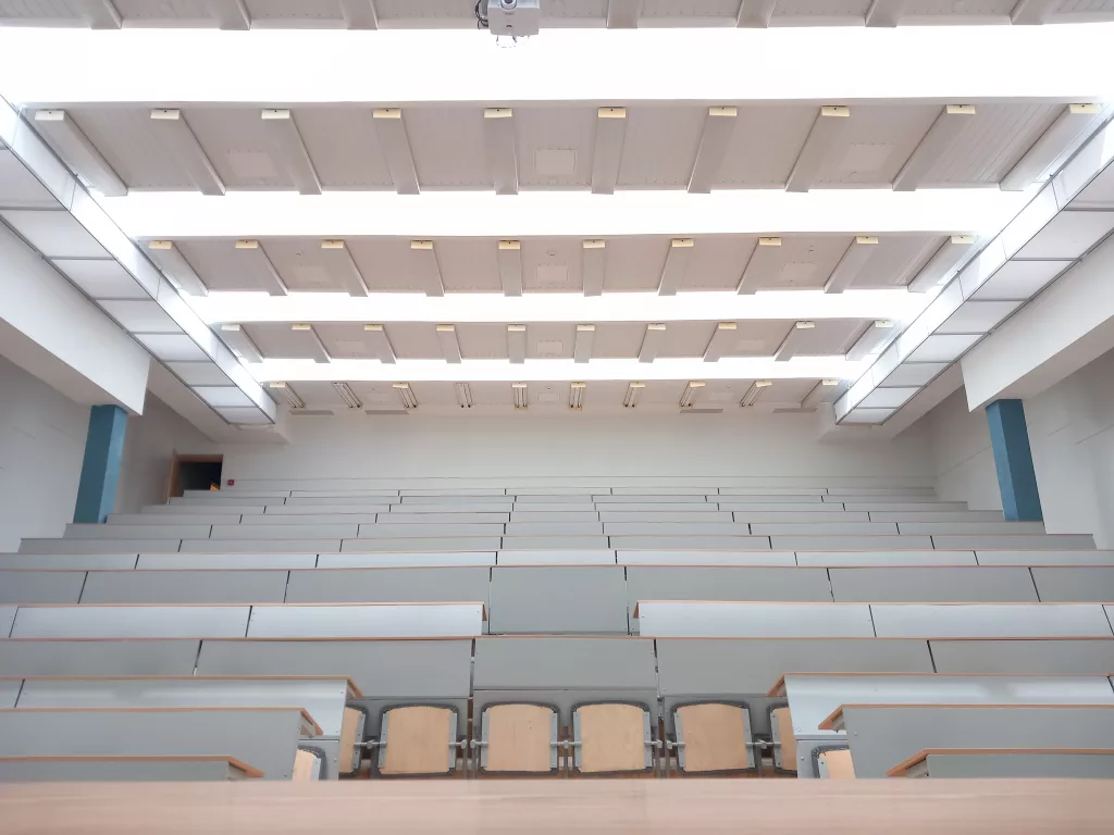 White rectangle-shaped fabric ducts installed on the left and right side of the ceiling in the Vilnius Gediminas Technical University auditorium to improve the indoor air quality and offer draft free airflow to ensure a comfortable learning environment for faculty and students.
