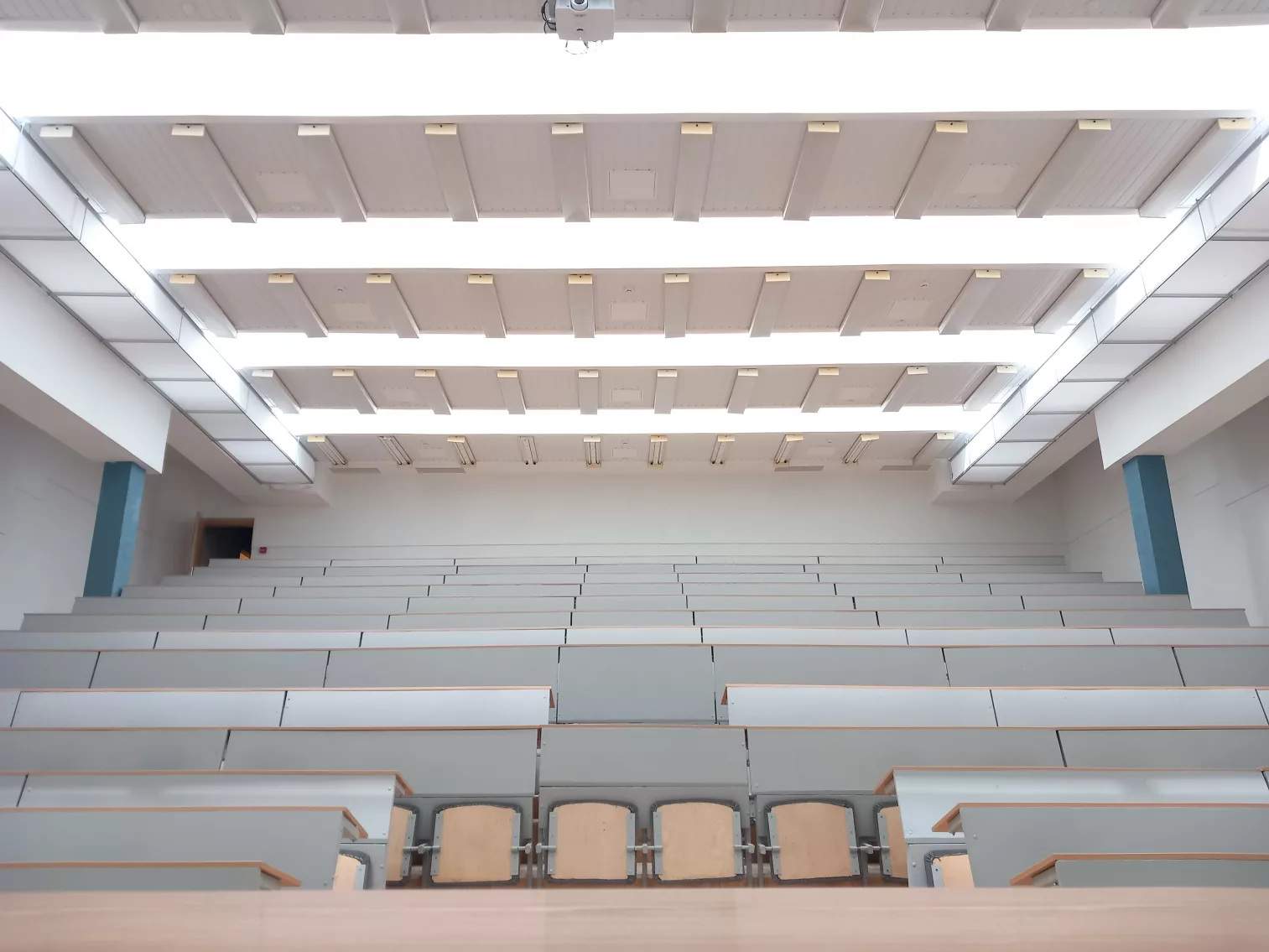 White rectangle-shaped fabric ducts installed on the left and right side of the ceiling in the Vilnius Gediminas Technical University auditorium to improve the indoor air quality and offer draft free airflow to ensure a comfortable learning environment for faculty and students.