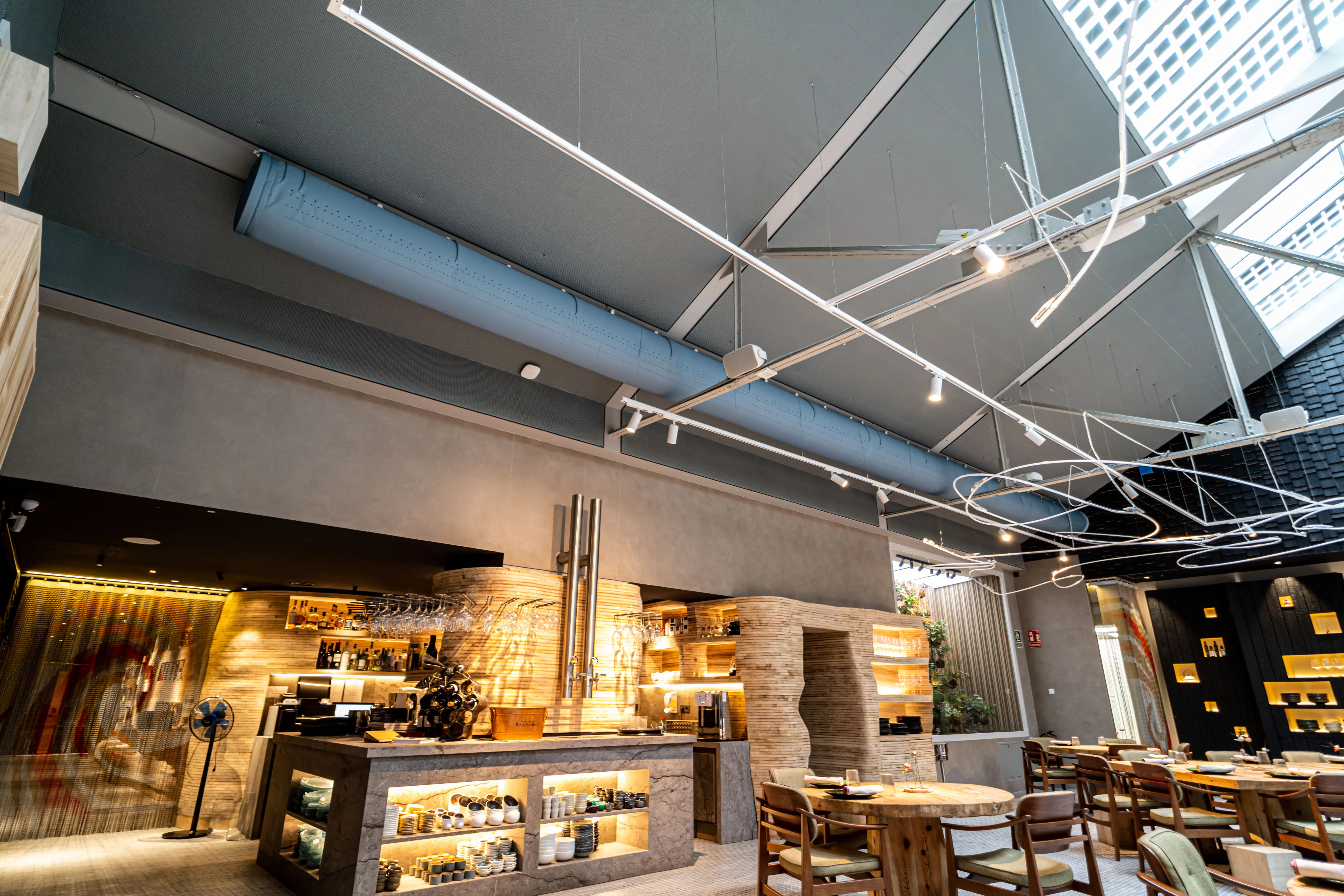 Gray fabric ducts installed in the dining room of Omeraki, a Michelin starred restaurant in Madrid.
