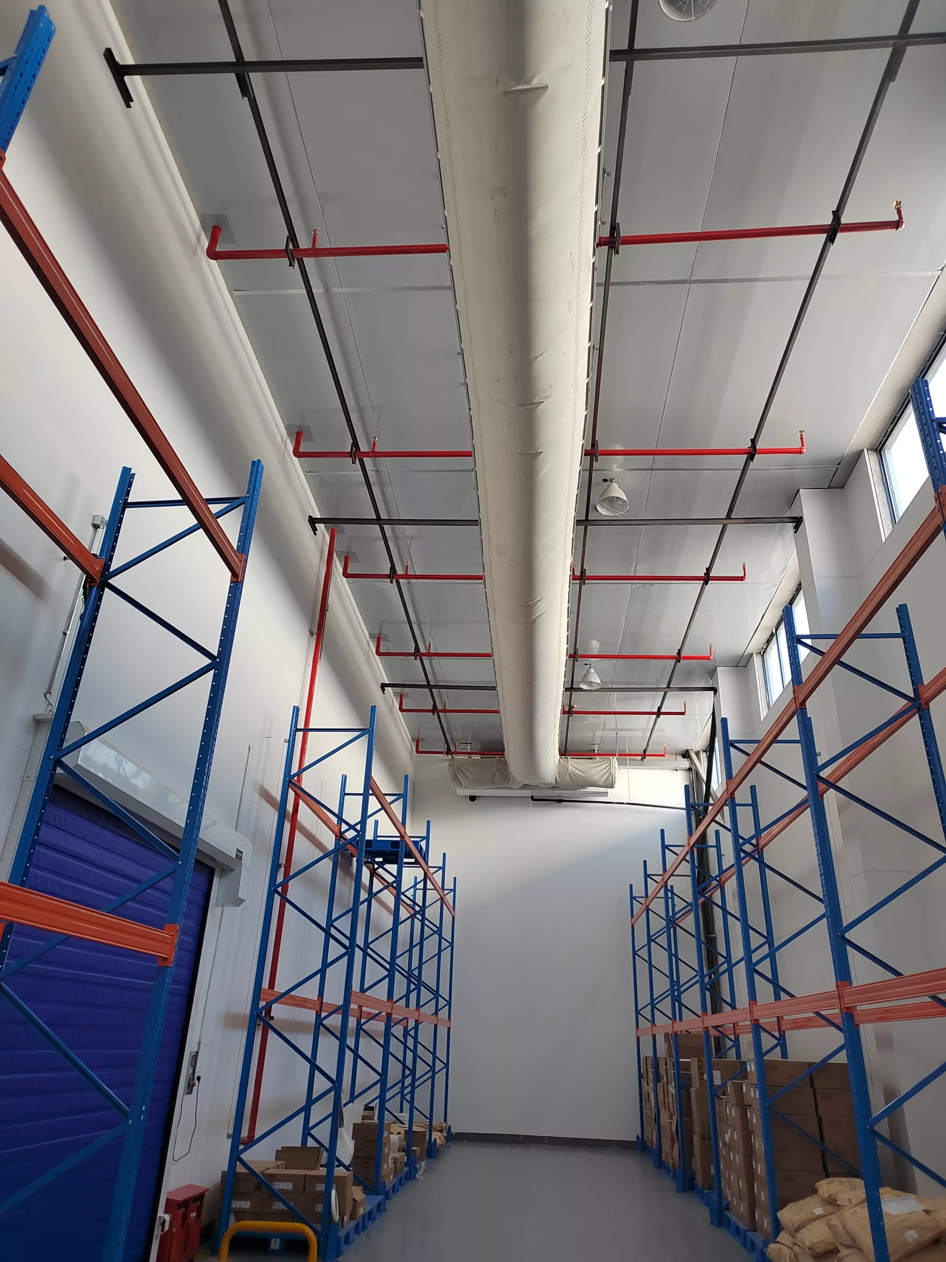 White fabric ducting using FabricAir’s Combi 20 fabric is installed in a pharmaceutical warehouse to optimize climate control.