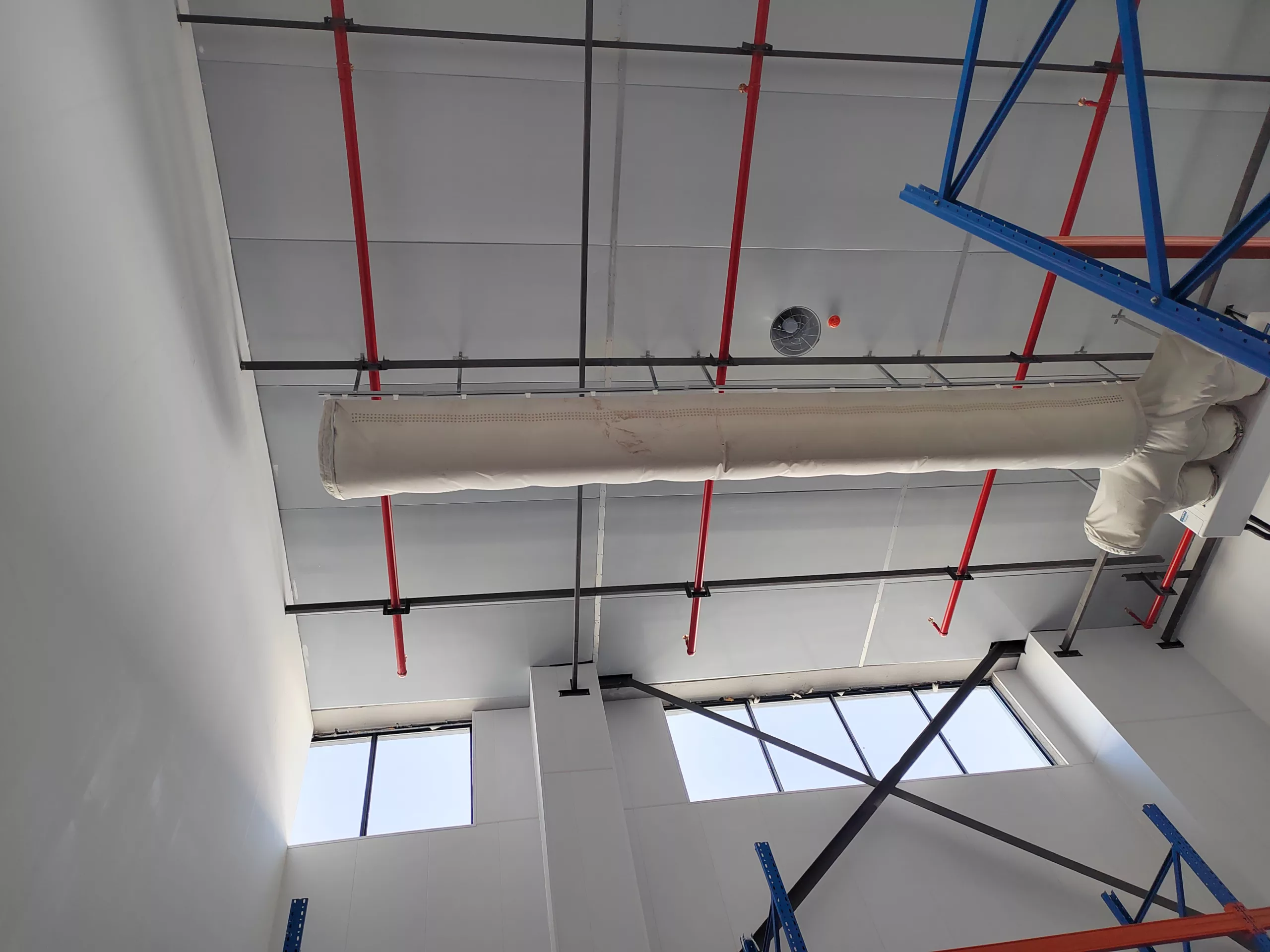 White fabric ducting using FabricAir’s Combi 20 fabric is installed in a pharmaceutical warehouse to optimize climate control.
