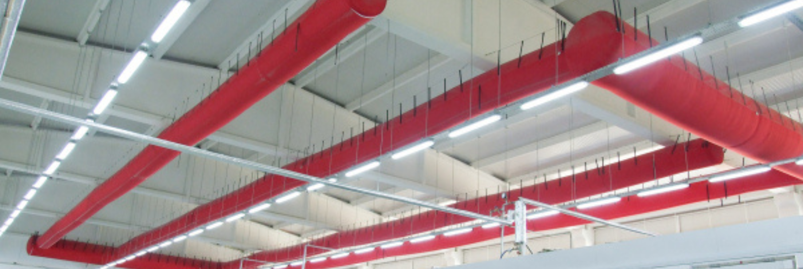 Red FabricAir ducts installed in a manufacturing facility
