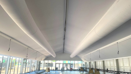 Lightweight, white fabric air ducts provide comfortable air dispersion in a temporary event spaces