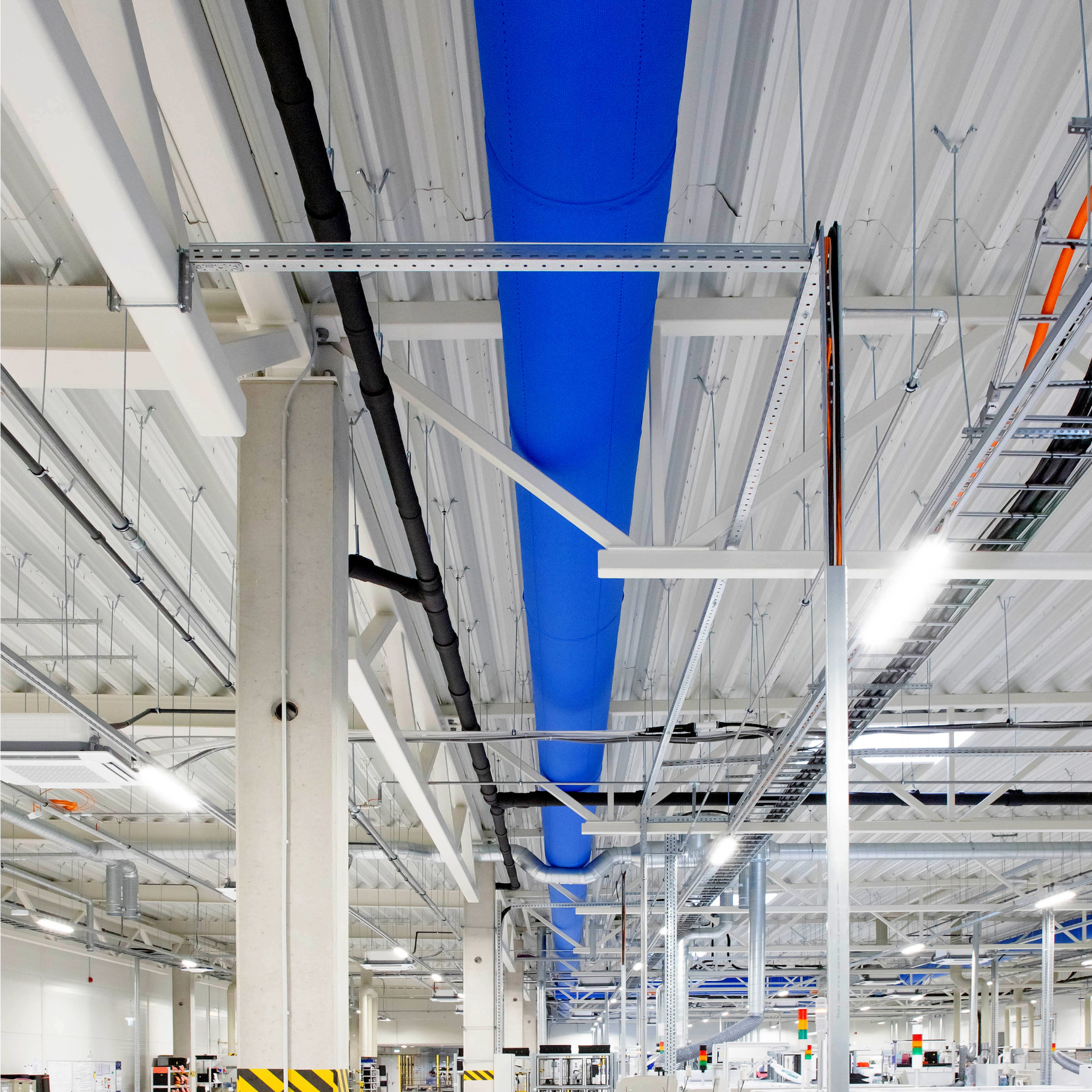 The bright blue fabric duct system installed in the new Axioma Metering factory to provide optimal conditions for sensitive machinery and materials.
