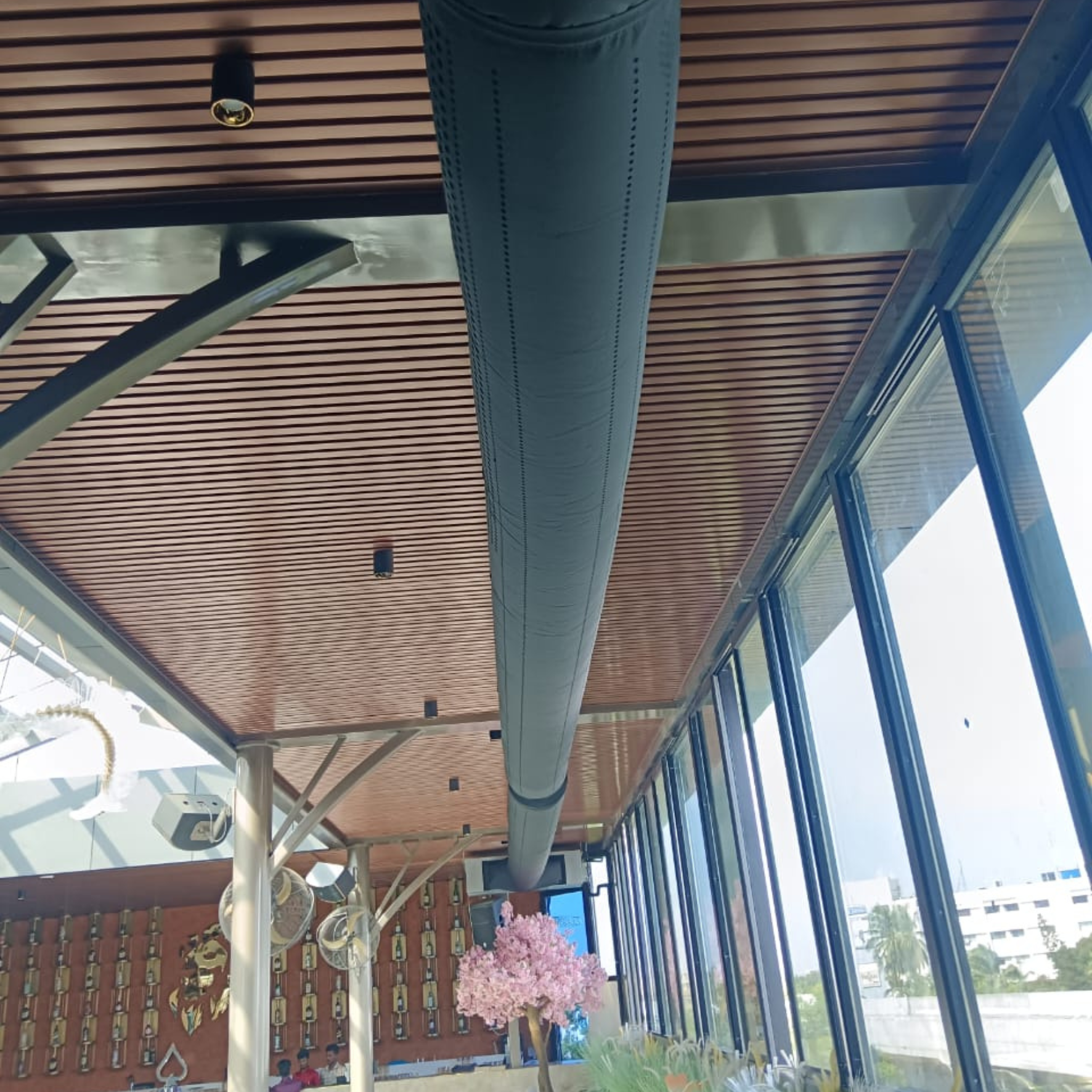 Sleek black fabric duct system provides comfortable, attractive, noiseless airflow for a modern restaurant in India