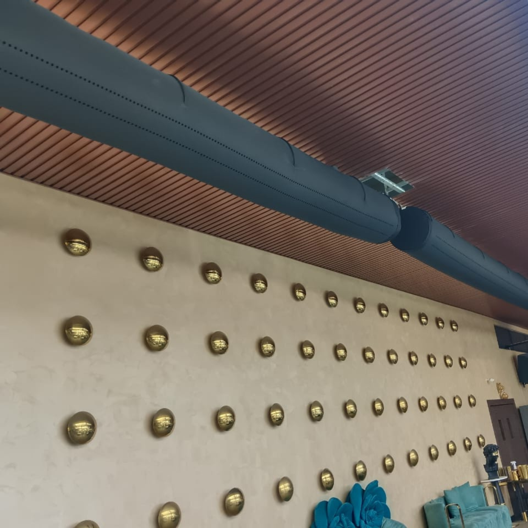 Sleek black fabric duct system provides comfortable, attractive, noiseless airflow for a modern restaurant in India