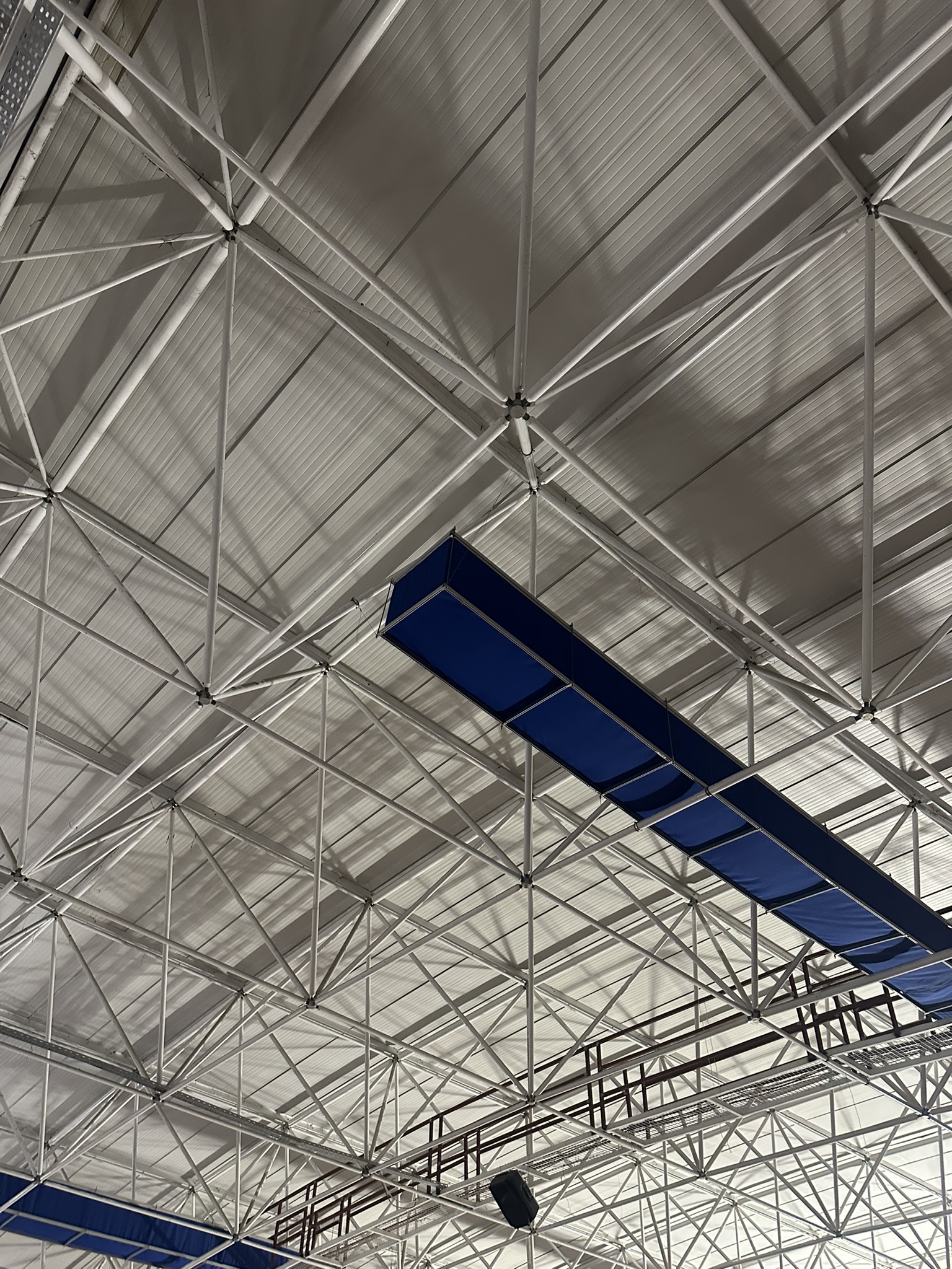 Blue and red fabric ducting provides ventilation and improves air quality in the Gazanfer Bilge Sports Hall in Istanbul