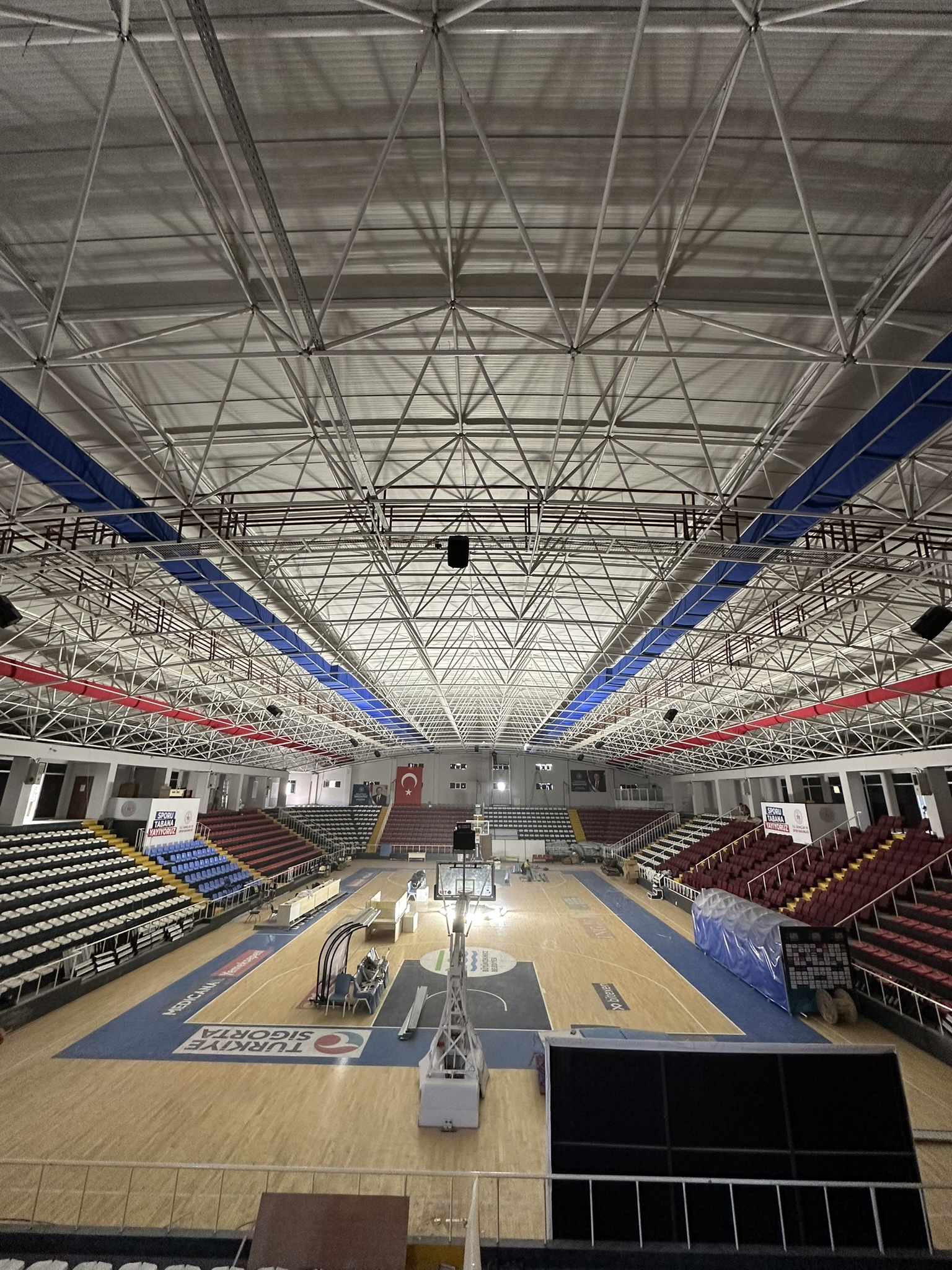 Blue and red fabric ducting provides ventilation and improves air quality in the Gazanfer Bilge Sports Hall in Istanbul