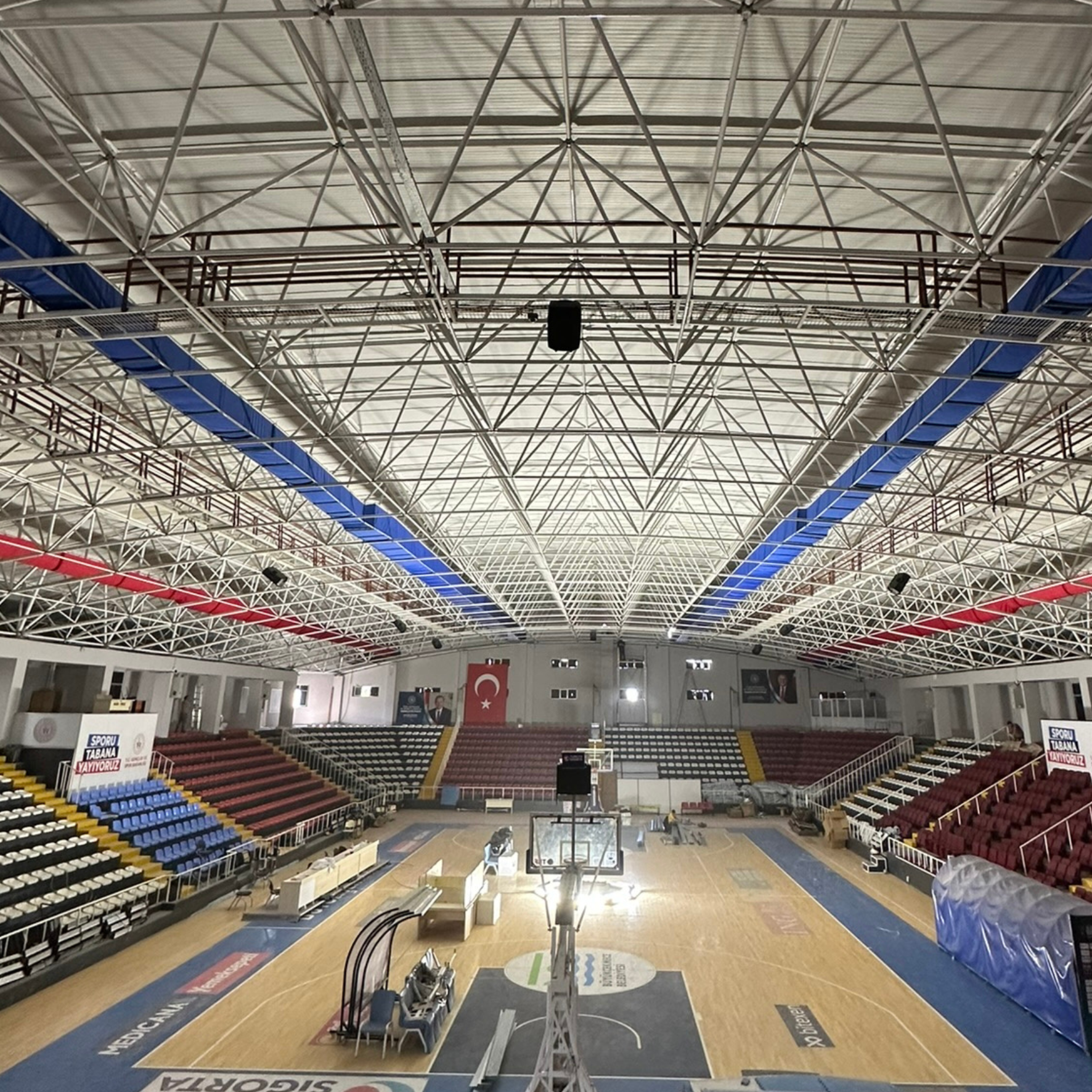 Blue and red fabric ducting provides ventilation and improves air quality in the Gazanfer Bilge Sports Hall in Istanbul
