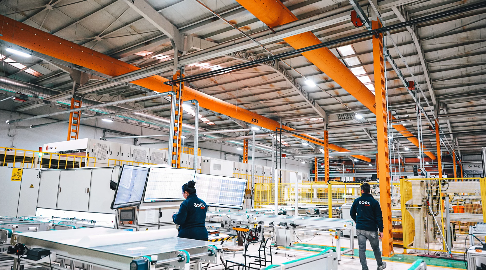 Yellow fabric air ducts with the Odul Solar logo hang in their manufacturing facility