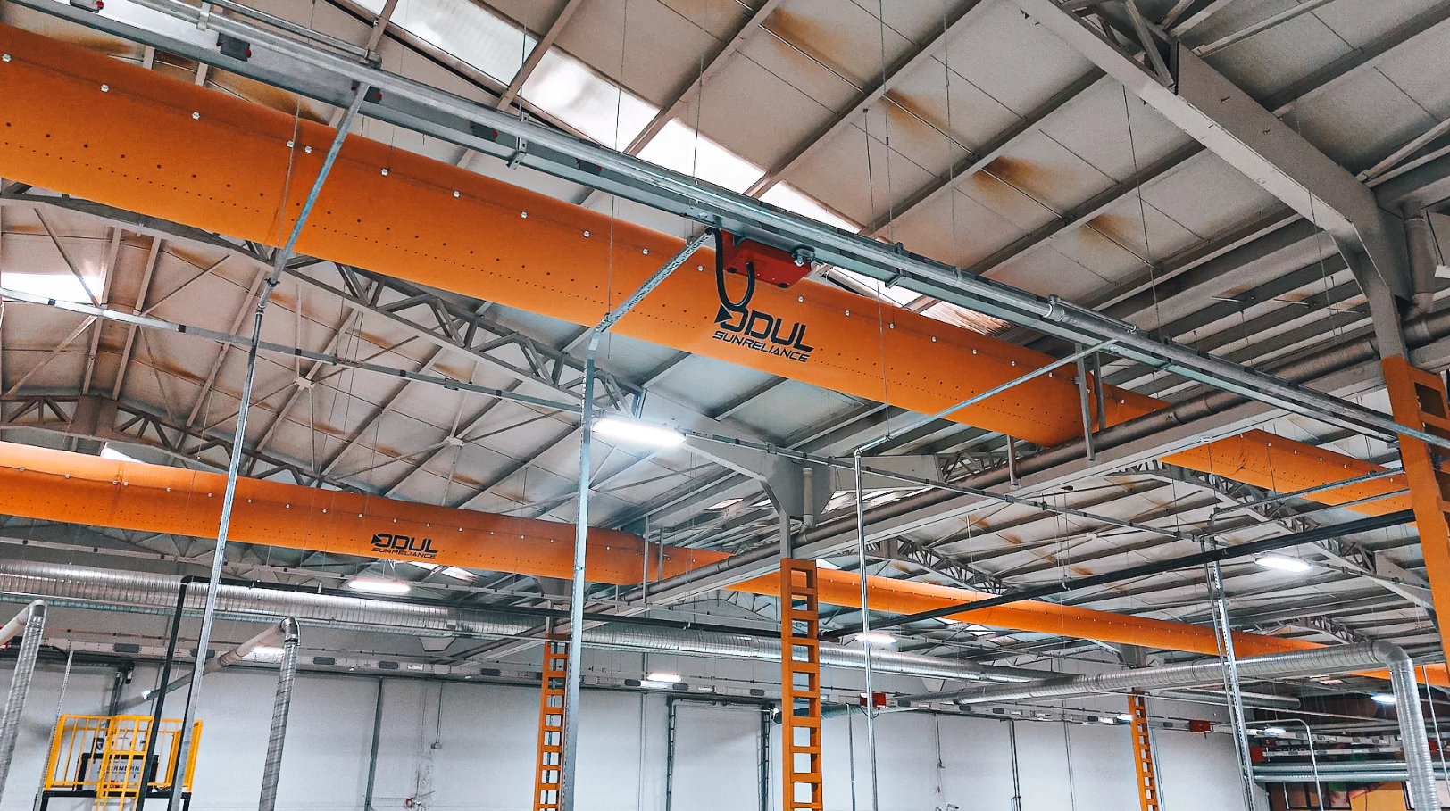 Yellow fabric air ducts with the Odul Solar logo hang in their manufacturing facility