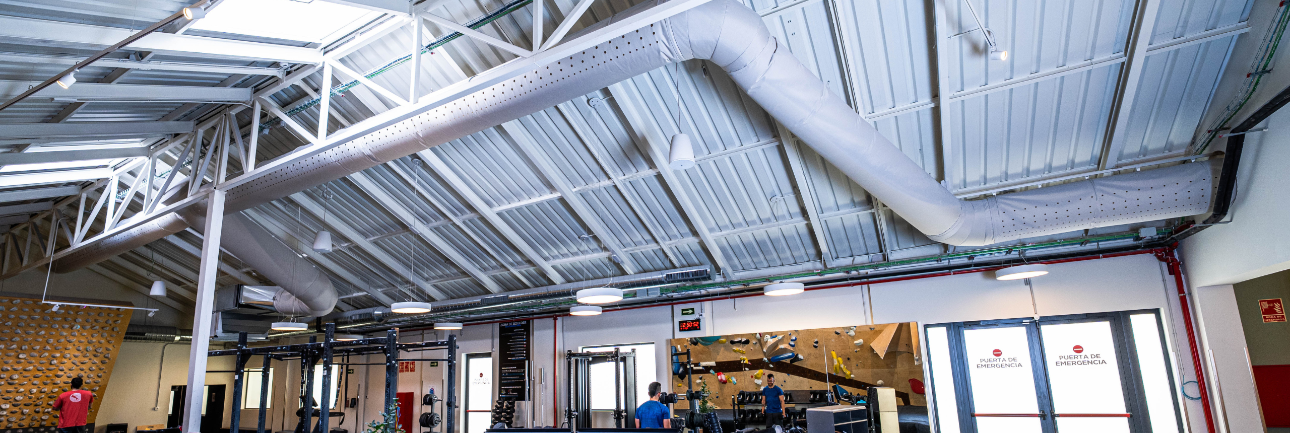 Gray fabric ducting provides draft-free ventilation to enhance comfort and safety at the Sputnik Climbing Gym in Madrid