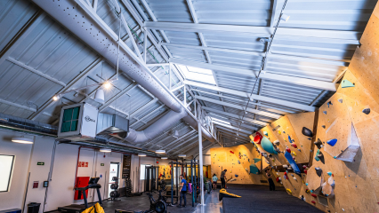 Gray fabric ducting provides draft-free ventilation to enhance comfort and safety at the Sputnik Climbing Gym in Madrid