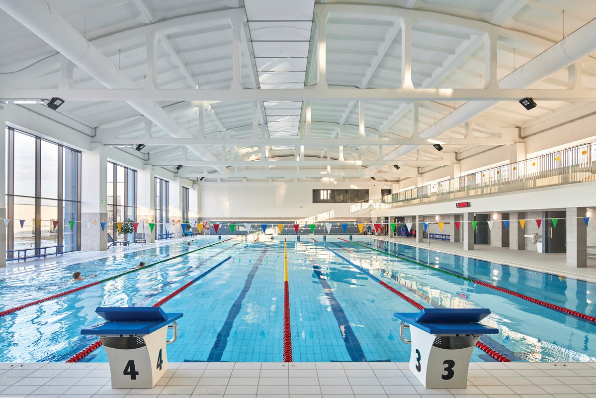 FabricAir's Return Air System is shown aesthetically installed in a pool. A taut rectangular structure complete with a perforated fabric draws contaminated air from the space complementing the supply system for perfect air distribution.