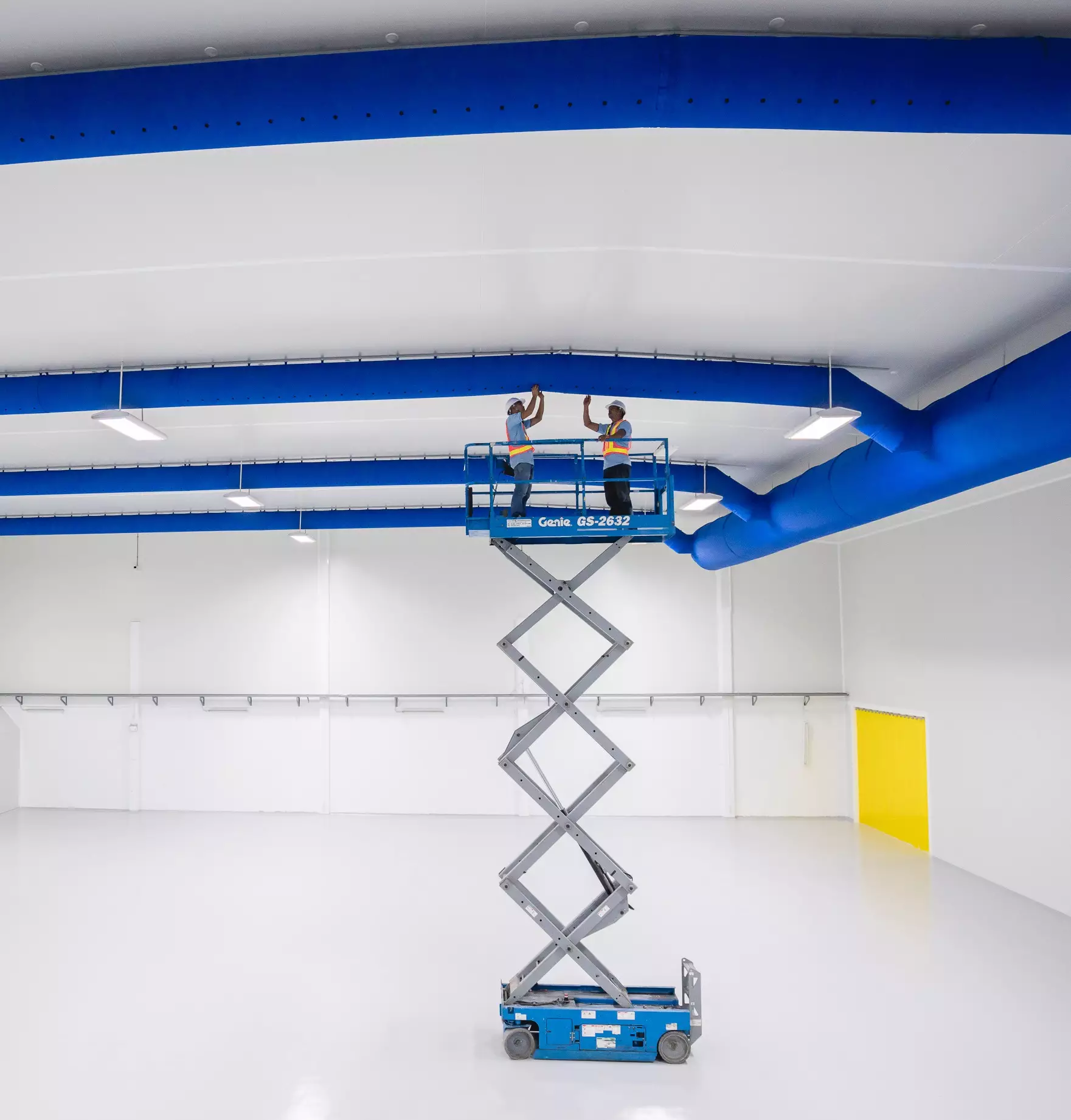Blue fabric duct systems being installed inside a chocolate factory